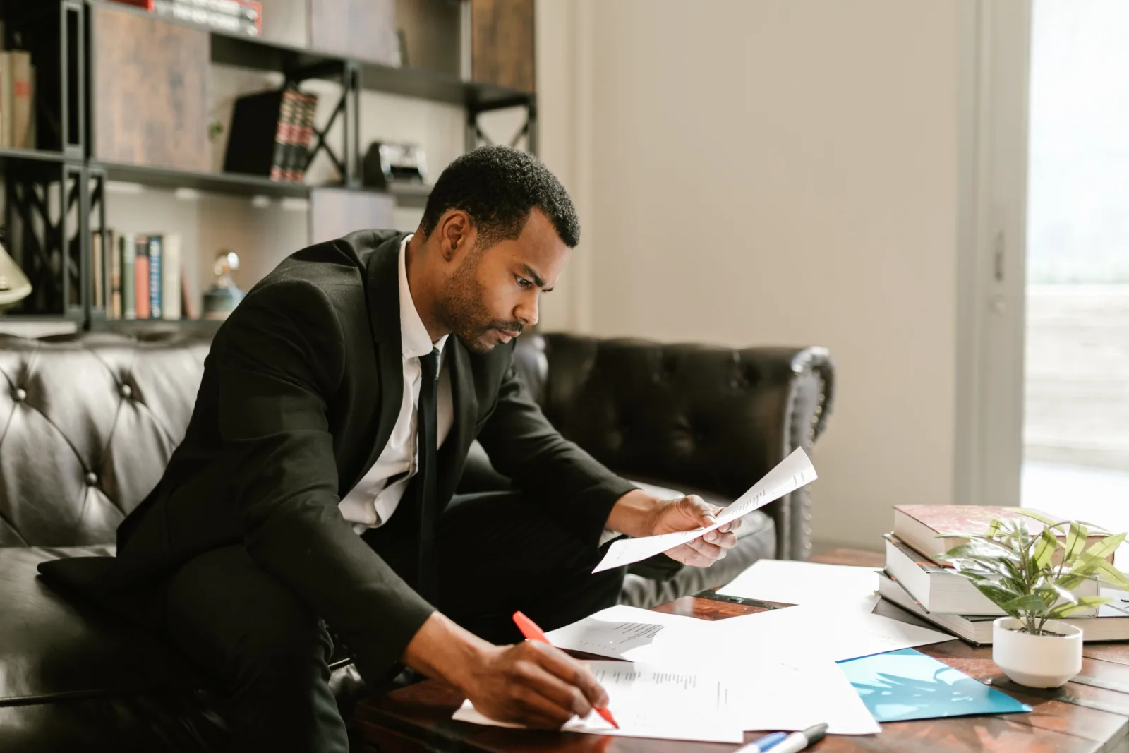 A business owner reviews paperwork as he tries to manage his business finances.