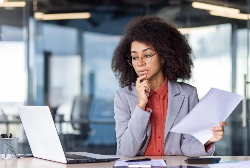 A professional carefully analysing a workplace challenge and considering possible solutions.
