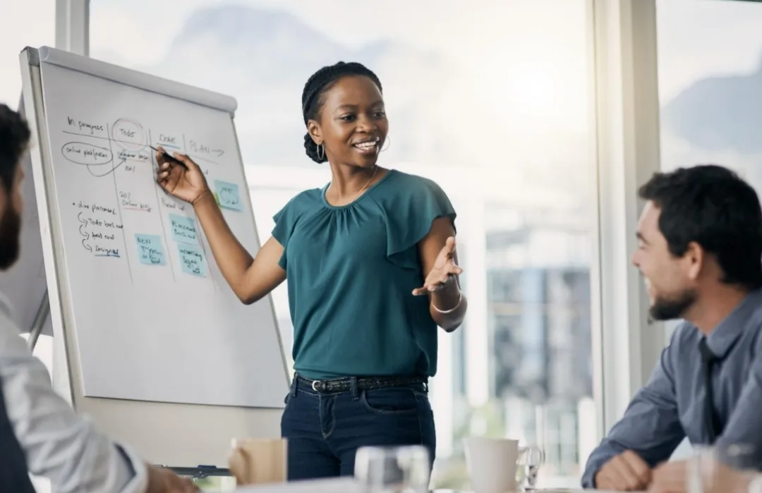 A professional woman confidently sharing ideas with a colleague during a workplace meeting.